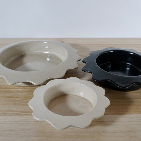 three serving bowls in different colours on a wooden table. 