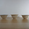line of three handmade stoneware snack bowls taken from the side. 