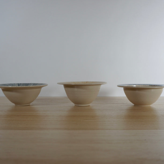 line of three handmade stoneware snack bowls taken from the side. 