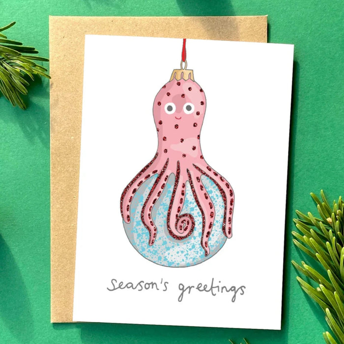 a kitsch christmas card with an illustration of a christmas tree decoration in the shape of an octopus. 