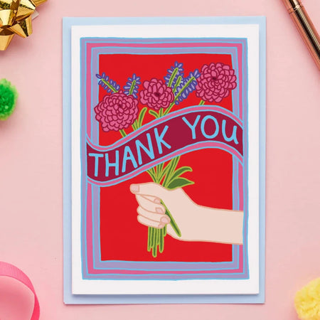 a card with an illustration of a hand holding a bunch of flowers and a banner that says thank you. 