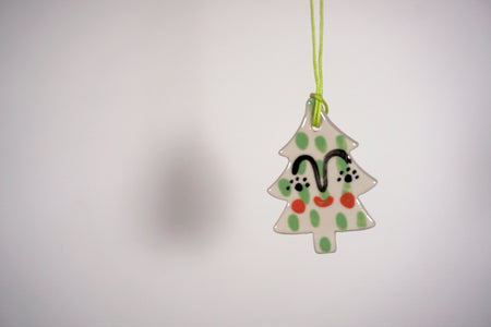 a hanging christmas tree decoration on a light coloured background. 