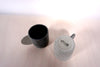 two grey espresso cups on a light background. one is lighter than the other and is upside-down so you can see the Brutes Ceramics makers mark.  