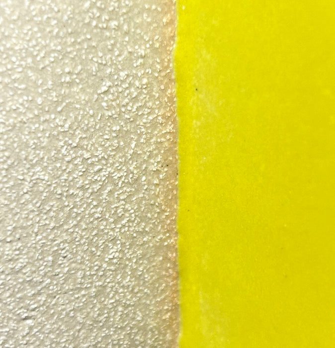 close up detail of sand clay and a bright yellow glaze. 