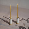 two white glazed stoneware candlestick holders with UK beeswax candles. 